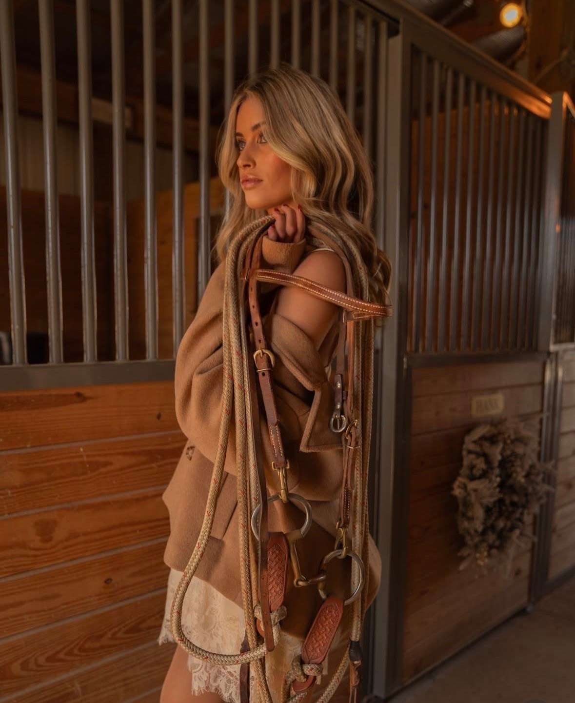 Editorial portrait in the barn aisle with tack